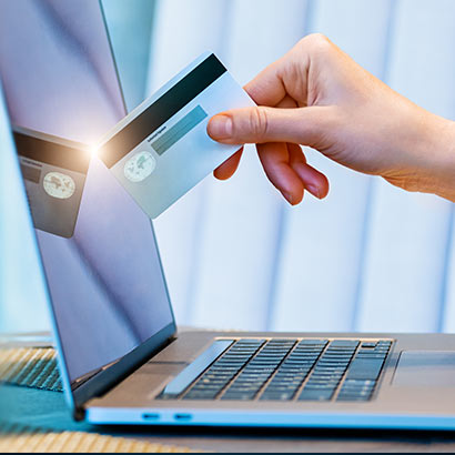 carta di credito che si riflette sullo schermo di un laptop